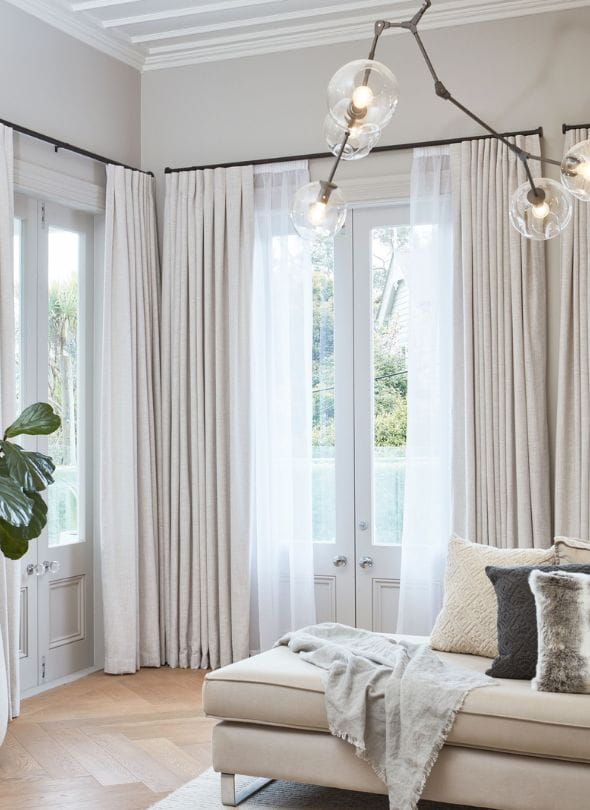 Cosy lounge room with layered curtains.