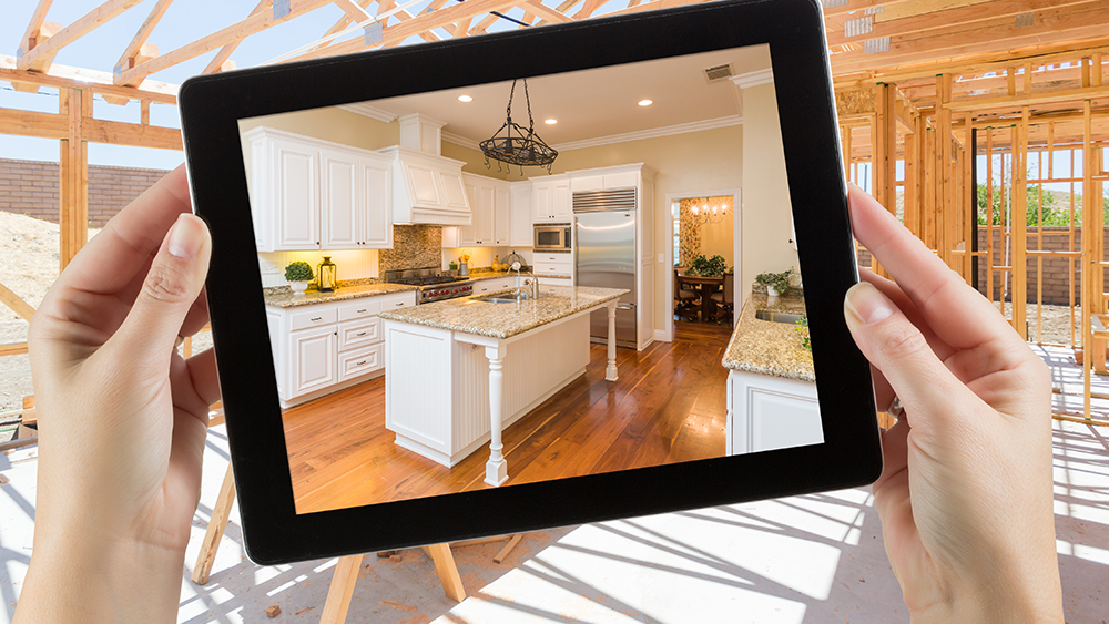 Hands holding iPad showing renovated kitchen