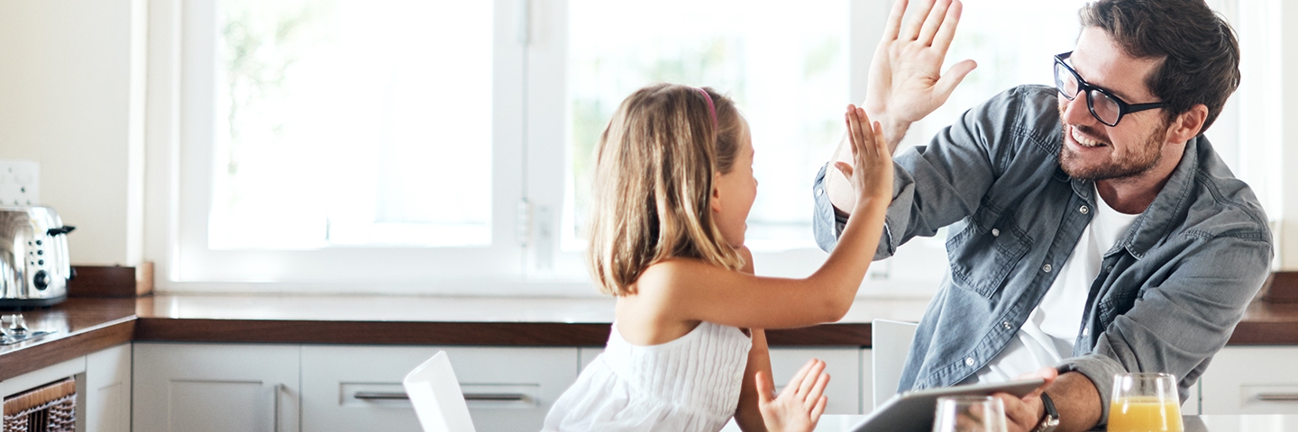 Daughter and father high fiving at kitchen table over free gas connection