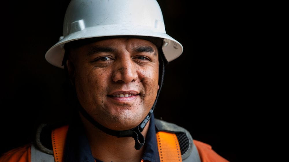 Man wearing work uniform and hard hat.