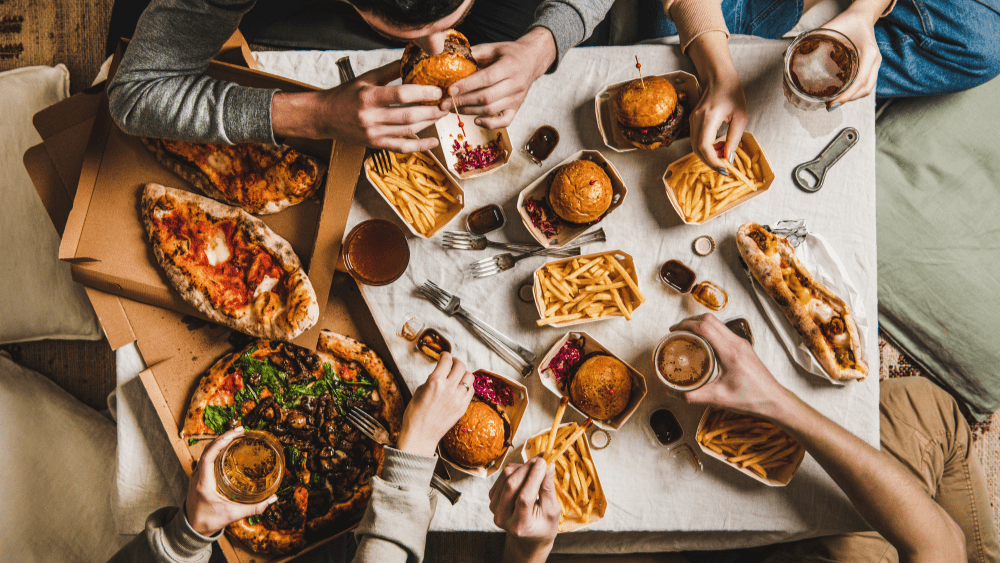 Table full of pizza, burgers and fries.
