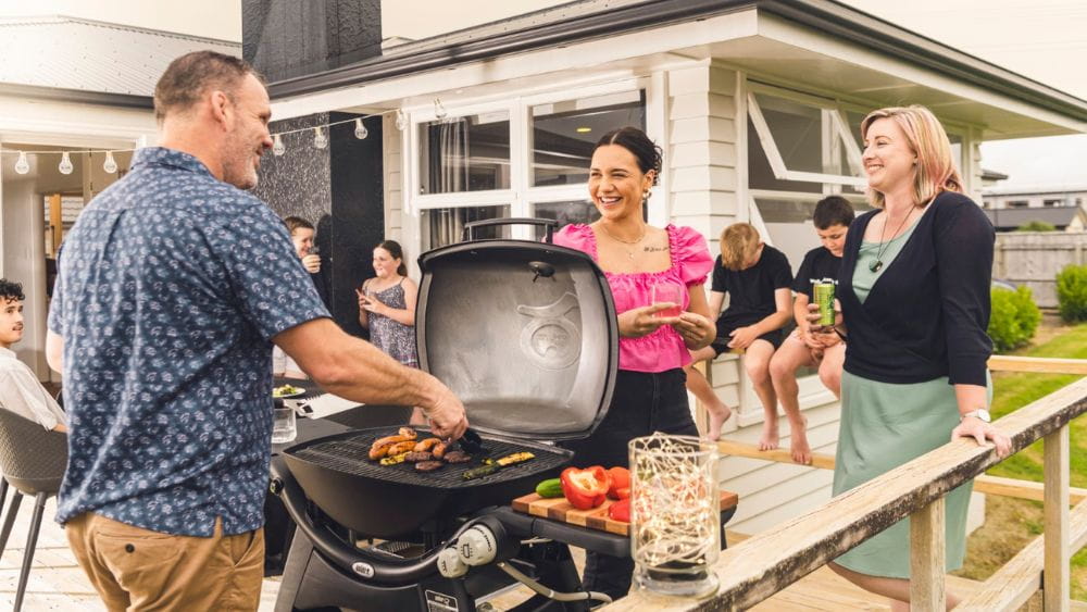 People enjoying a BBQ on the deck in summer.