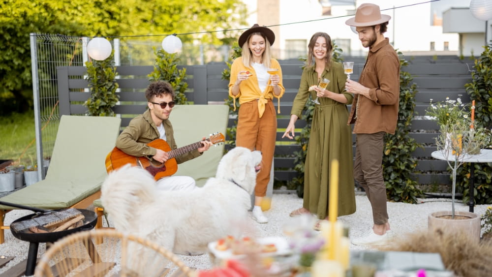 four people standing on a deck having a bbq listening to music.
