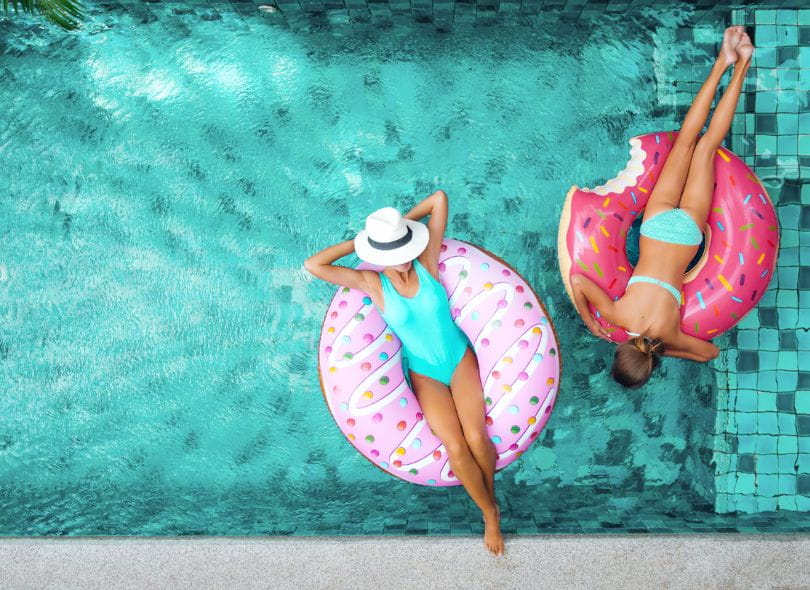 Two women on inflatables in a pool.