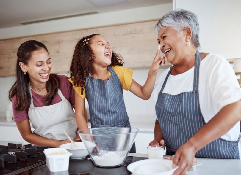 Mother, daughter and grandmother cooking in kitchen.