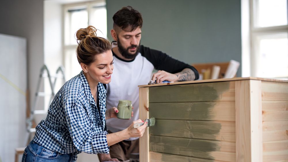 A man and women painting a planter box.