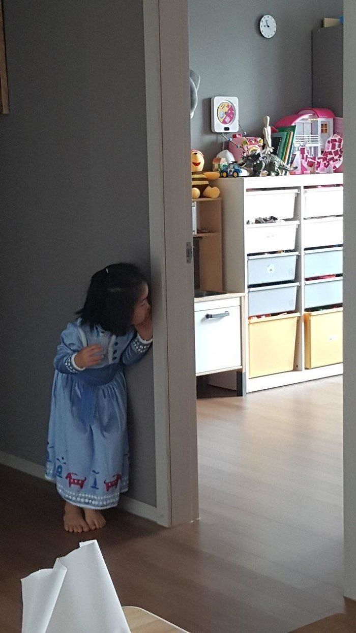 Little girl peeks around the door.