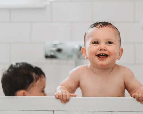 Small child in bath tub heated by gas hot water
