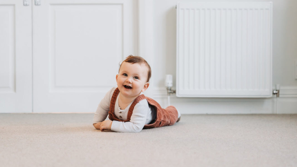 young child on floor in front of gas radiator