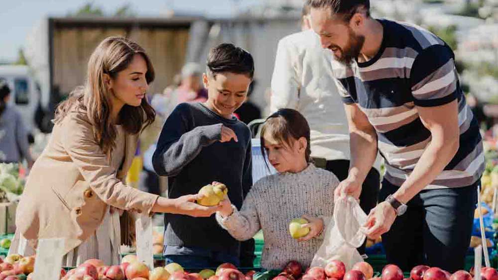 family picking fruit at market