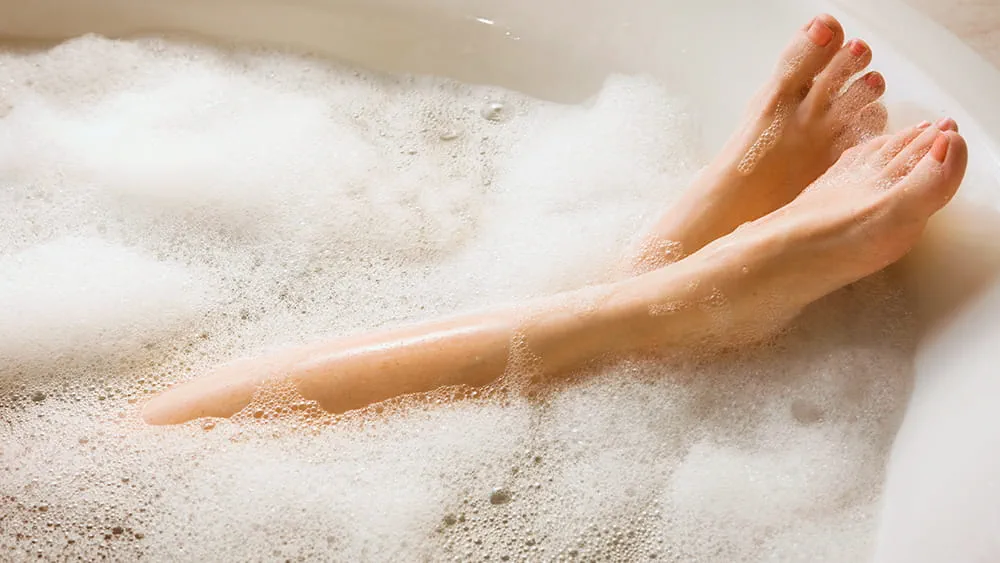 Women's feet in bubble bath powered by natural gas hot water