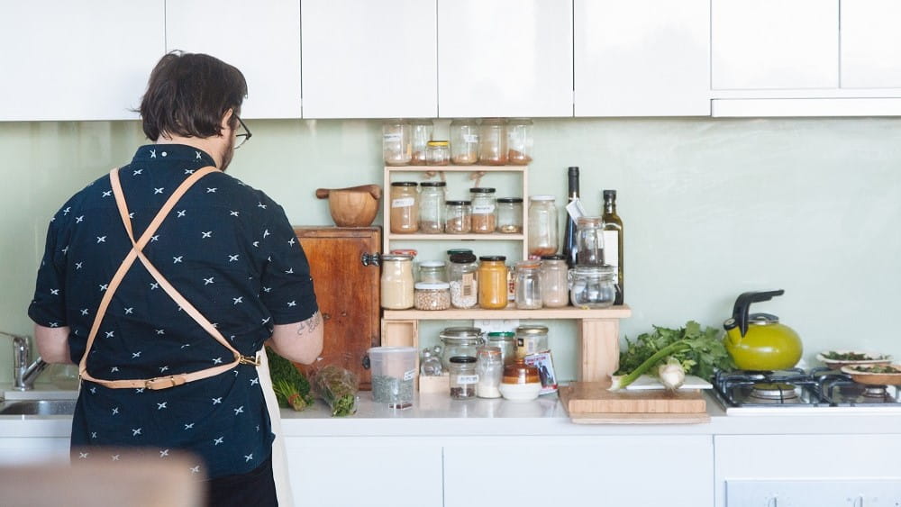 Man in kitchen cooking with gas