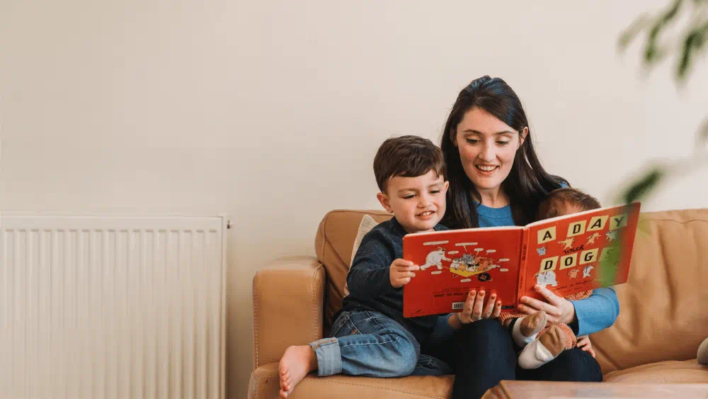 Mother and children reading in front of natural gas radiator.