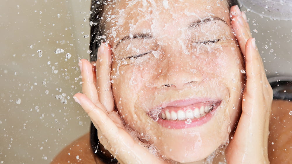 Woman splashing water on face