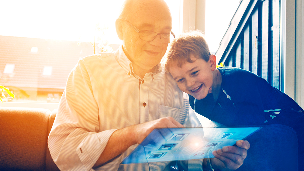 Grandfather and grandson on futuristic smart home device