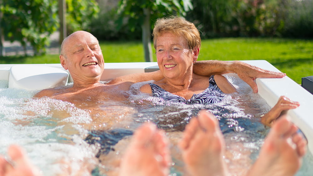 Older couple with feet up in spa pool