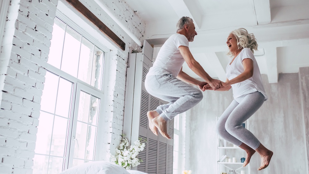 Older couple jumping on bed excitedly for free connection