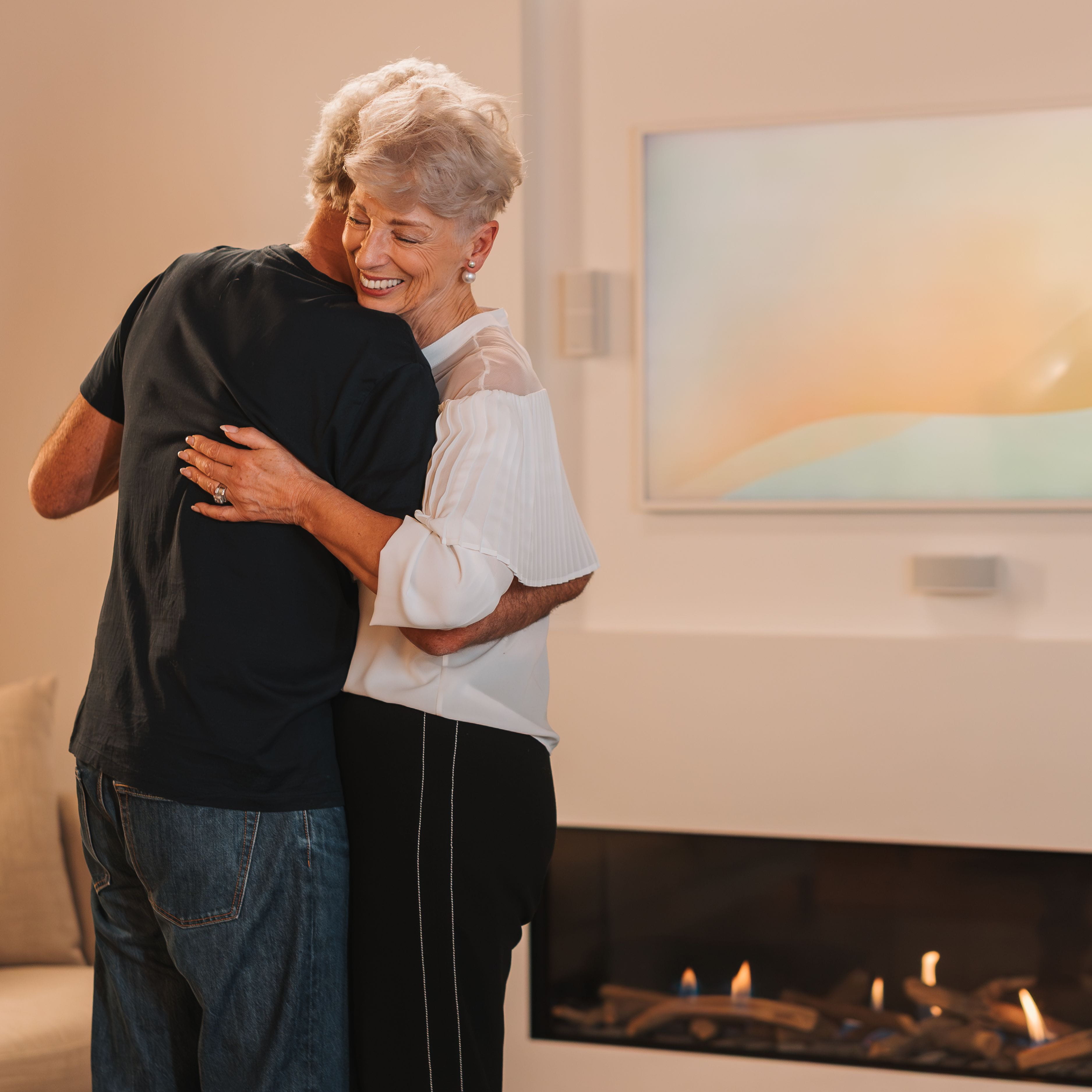 Couple dancing in their living room in front of natural gas fire.